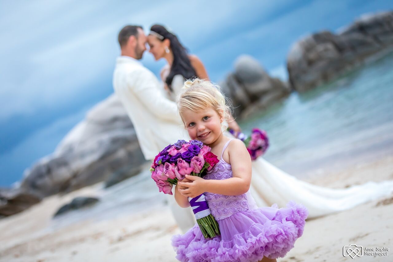 Flower girl and married couple on a beach near Port Douglas